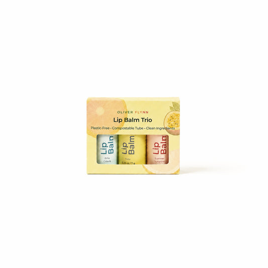 Oliver Flynn limited-edition Summer Lip Balm Trio in Summer Sunshine, Yuzu, and Piña Colada, made with beeswax, plant oils, and vitamin E.