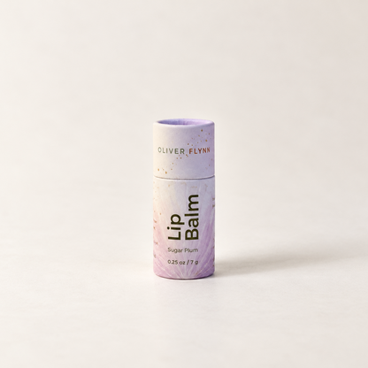 Oliver Flynn Lip Balm in the Sugar Plum tube packaging, standing upright on a clean white surface against a white background.
