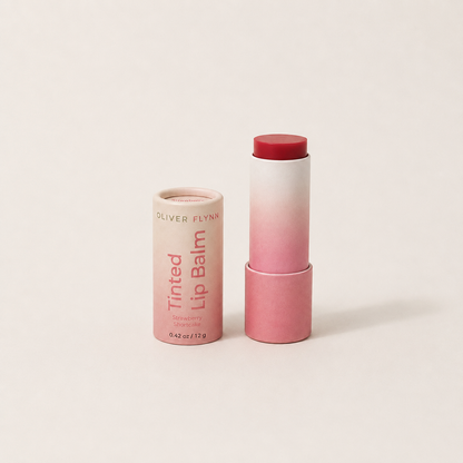 Oliver Flynn Strawberry Shortcake Tinted Lip Balm with a sheer, buildable strawberry-pink tint for moisturized lips and a natural rosy glow.